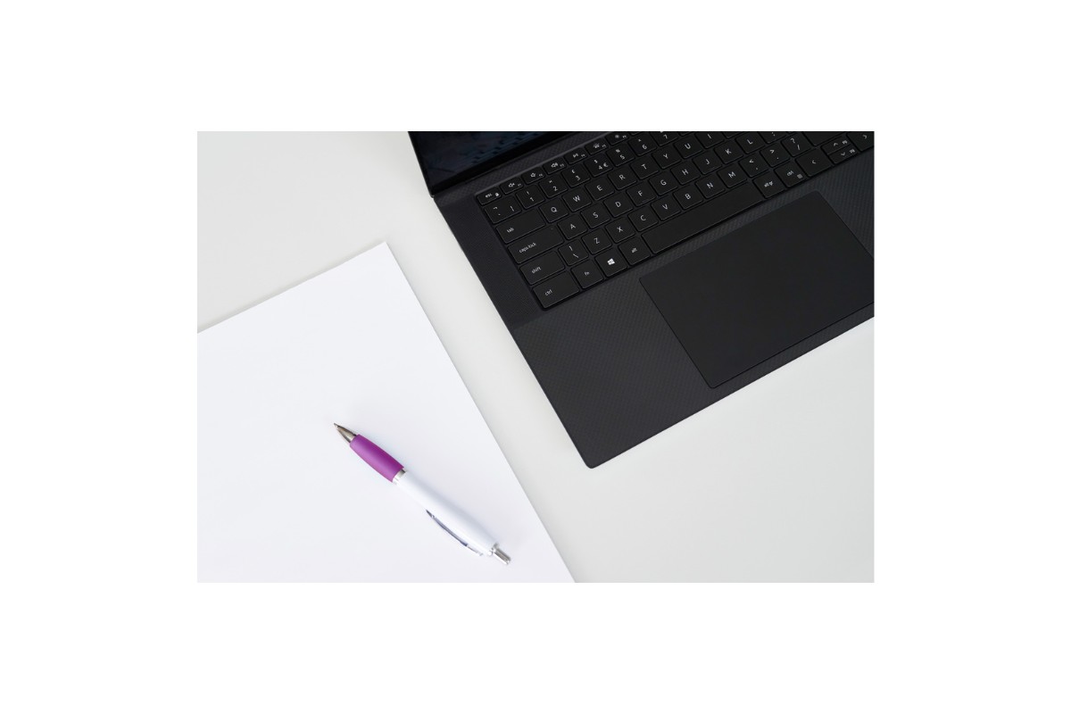Photo of black laptop, white notepad and pen